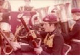 Small colour photo of a member of 1 PARA band playing a bassoon.