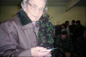 An old woman who gives British troops prayer cards is caught by the photographer