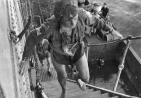 Officer of the 1st Airlanding Brigade climbs aboard a ship after his glider landed in the sea. July 1943. 