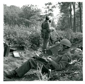 War correspondent Alan Wood sits with a typewriter in grounds of Hartenstein Hotel.