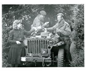 Two members of the AFPU drink tea in a jeep.