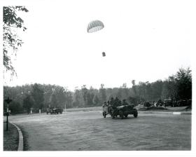 A supply container dropping on the green opposite the Hartenstein, whilst RASC Jeeps drive past on their way to the SDP.