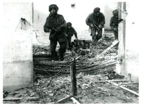 Posed shot of four paratroopers amid debris in Oosterbeek.