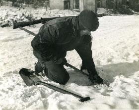 Lance Corporal Newton searching for enemy mines in the snow. January 1945