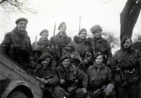 John Arthur kneeling with large glove on his hand as he suffered frostbite in the Ardennes