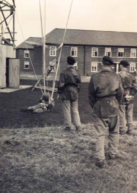 Members of 629 Airborne Light Regiment landing after jumping from the tower RAF Abingdon 1955