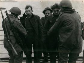 Troops search a German prisoner captured at Bruneval, 1942.