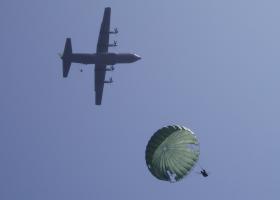 Ginkel Heide 2009 Arnhem 65th Commemoration:US Paratrooper descending  while another stick starts to exit in the C130 overhead