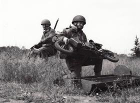 Paratrooper unloading an Airborne Welbike from supply drop container