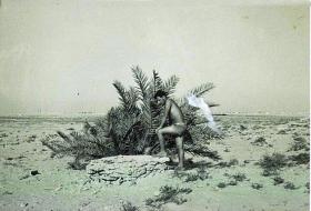 An unidentified member of 7 Para Lt Regt RHA looks into a desert well, Bahrain c 1963.