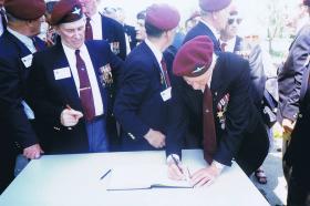Paul Aller signs the Mayors book, having been given Freedom of Benouville, June 1996